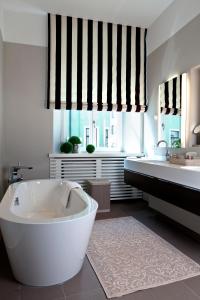 a white bath tub sitting under a window in a bathroom at Hotel Bischofshof am Dom in Regensburg