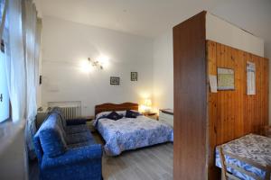 フォルテ・デイ・マルミにあるLa Mimosaのベッドルーム1室(ベッド2台、青いソファ付)