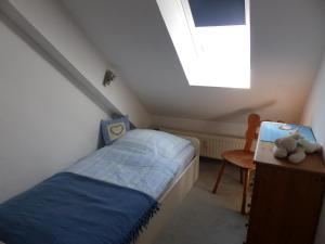 a small bedroom with a bed and a window at Ferienwohnung Meisennest in Cuxhaven