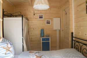 a bedroom with a bed with a wooden wall at Glantalhütte in Glan-Münchweiler