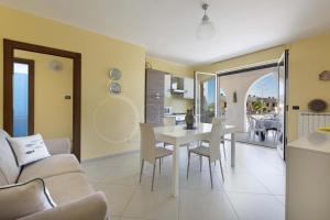 Un comedor y una sala de estar con mesa y sillas. en Aurora D'Otranto, en Otranto