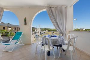 Un comedor con mesa y sillas y un balcón. en Aurora D'Otranto, en Otranto