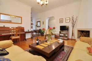 a living room with a table and a piano at San Rocco Apartment in Corfu