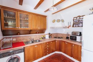 una cocina con armarios de madera y fregadero en Casa Rural La Herradura del río Júcar, en Jorquera
