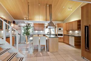 eine Küche mit Holzschränken, einem Tisch und Stühlen in der Unterkunft Villa SUNSET in Malax