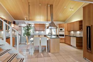 a kitchen with wooden cabinets and a table and chairs at Villa SUNSET in Malax