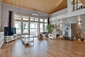ein großes Wohnzimmer mit Kamin und Fernseher in der Unterkunft Villa SUNSET in Malax