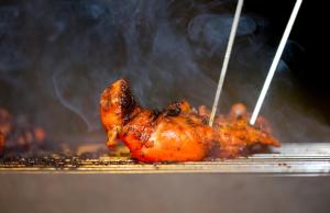 a piece of chicken being grilled on a grill at Hide Yala in Tissamaharama