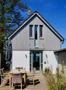 a house with a table and chairs in front of it at Strandhus17 in Steinhude