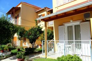 a house with a balcony in front of it at Rantos Apartments in Kavos