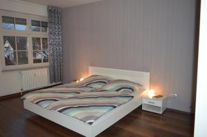 a bedroom with a large bed with two lights on it at Ferienwohnung "Haus 10" in Essen