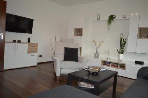 een woonkamer met een bank, een stoel en een tafel bij Ferienwohnung "Haus 10" in Essen