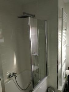 La salle de bains est pourvue d'une douche avec une porte en verre. dans l'établissement Ferienwohnung "Haus 10", à Essen