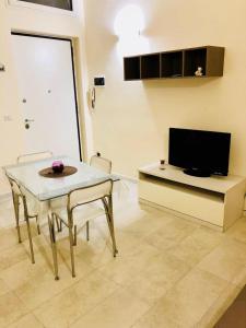 Una sala de estar con una mesa y un televisor. en Sogni D'oro, en Bari