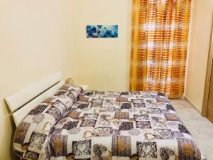 Una cama con edredón en un dormitorio en Sogni D'oro, en Bari