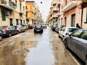 una calle húmeda con coches aparcados en la calle en Sogni D'oro, en Bari