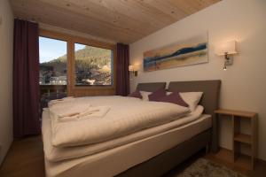 una camera da letto con un grande letto con una grande finestra di Chalet Belmont Penthouse a Wengen