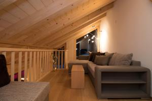 un soggiorno con divano e soffitto in legno di Chalet Belmont Penthouse a Wengen