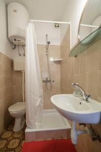 Un baño con lavabo, inodoro y ducha. en Apartmani Jordana, en Komiža 31 fotos más