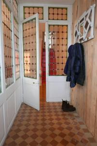 un couloir avec une porte et un chat assis sur le sol dans l'établissement Le Charlot, à Saint-Valery-sur-Somme