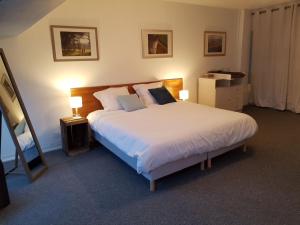 une chambre avec un grand lit blanc avec deux lampes dans l'établissement Le Charlot, à Saint-Valery-sur-Somme