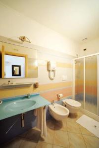 a bathroom with a sink and a toilet and a shower at Hotel Cristina in Rocca San Giovanni