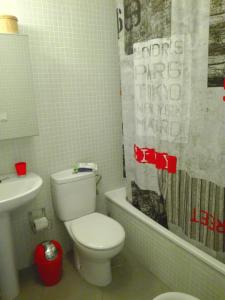 a bathroom with a toilet and a sink and a tub at Residencial Los Martines in El Médano