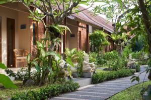 un jardín con estatuas frente a un edificio en The Garden Villa, en Sanur