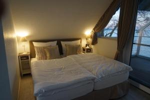 a bedroom with a large white bed and a window at Strandhus17 in Steinhude