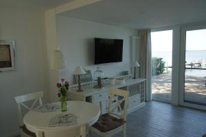 a dining room with a table and a television on the wall at Strandhus17 in Steinhude