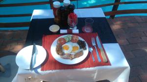 une assiette de denrées alimentaires contenant des œufs et des légumes sur une table dans l'établissement Villa Helderberg, à Somerset West