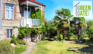 una casa con un balcone e una palma di GreenGate a Gurjaani