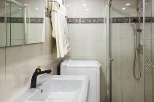 a bathroom with a shower and a sink and a toilet at Milano Suite in Lev Eilat in Eilat +25 photos