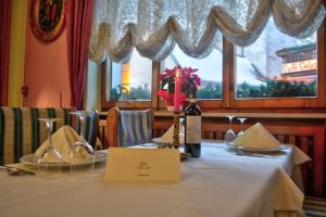 a table in a restaurant with a bottle of wine at Hotel Alle Alpi in Alleghe