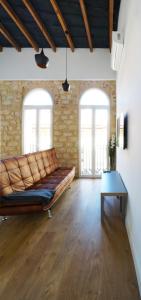 ein Wohnzimmer mit Ledersofa und zwei Fenstern in der Unterkunft Alicante old city & beach appartment in Alicante