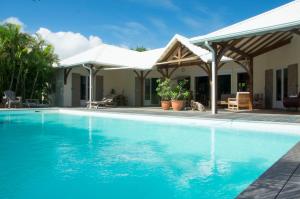 - une piscine en face d'une maison dans l'établissement Villa Tiarés, à Saint-François
