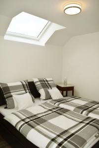 a bed with black and white sheets and a skylight at Ferienwohnung Palmen in Gangelt