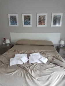 ein Bett mit zwei weißen Handtüchern darüber in der Unterkunft Appartamento Adda con posto auto in Olginate
