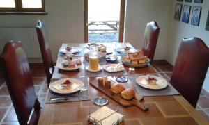 a dining room table with breakfast foods and orange juice at The Magnolias B&B in Moyon +13 photos