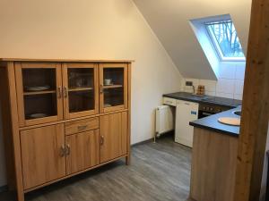 a kitchen with a large wooden cabinet and a sink at Apartment-Pension Schwalbennest in Herzogenaurach