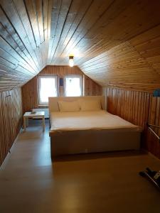 1 dormitorio con 1 cama en una cabaña de madera en Lelia Residence Apartments, en Brasov