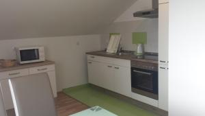 a kitchen with white cabinets and a microwave at Apartma Rodica in Domžale