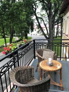 a patio with two chairs and a table on a balcony at Hotel Benevilla in Alūksne