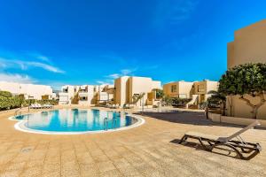 a swimming pool in the middle of a resort at Family Townhouse La Tejita in La Tejita