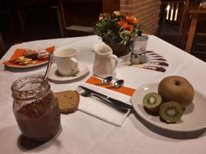 a white table with a plate of food and fruit on it at Agriturismo Cabrele in Santorso