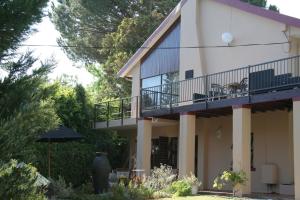 une maison dotée d'un balcon avec un chien. dans l'établissement Villa Helderberg, à Somerset West