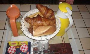 a plate of bread and croissants on a table at Le chant des oiseaux chambre pour deux à quelques minutes de la Baie de Somme entre nature mer et télétravail in Nibas +13 photos
