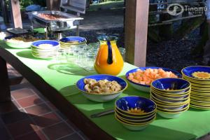 uma mesa com tigelas azuis e pratos de comida em Tinamu Birding em La Manuelita