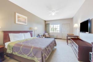 a hotel room with a bed and a flat screen tv at Lone Star Inn - San Benito in San Benito