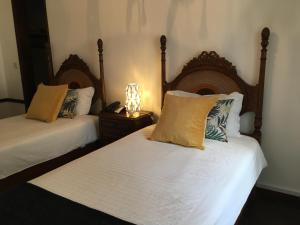 a bedroom with two beds and a table with a lamp at Hotel Ribamar in Nazaré